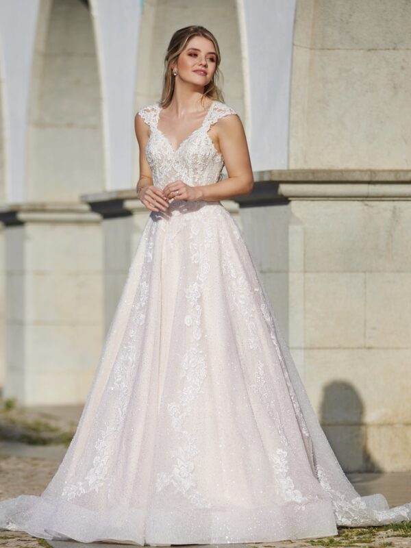 Robe de mariée élégante avec dentelle délicate et décolleté plongeant, prise en photo devant des arches en pierre