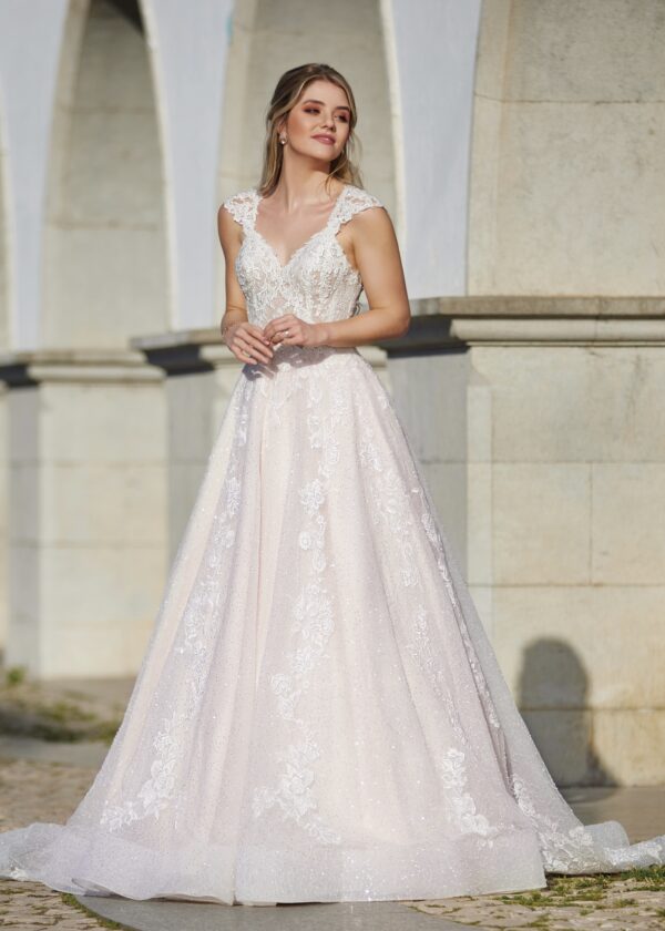 Robe de mariée élégante avec dentelle délicate et décolleté plongeant, prise en photo devant des arches en pierre