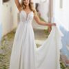 Robe de mariée sans manches à jupe fluide, modèle tenant la jupe avec un sourire enjoué