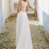 Robe de mariée fluide avec dos en dentelle transparente, modèle en promenade dans une ruelle pavée