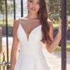 Femme en robe de mariée blanche près d'une grille en fer forgé