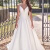 Portrait en gros plan d'une mariée portant une robe de mariée avec bretelles fines et broderies florales