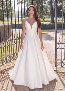 Portrait en gros plan d'une mariée portant une robe de mariée avec bretelles fines et broderies florales