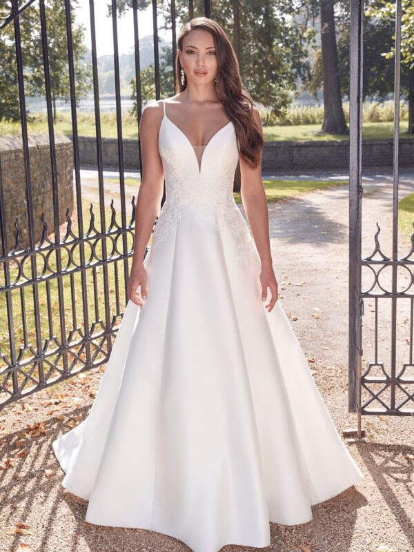 Portrait en gros plan d'une mariée portant une robe de mariée avec bretelles fines et broderies florales