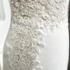 Mariée en robe de mariée élégante avec manches courtes en dentelle et une longue traîne, dans une salle lumineuse