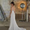 Vue de dos de la robe de mariée Jacinthe mettant en valeur son dos plongeant en dentelle et sa traîne fluide, photographiée dans un décor industriel rustique
