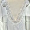 Vue de face d'une mariée en robe blanche à manches courtes et encolure en V ornée de dentelle délicate