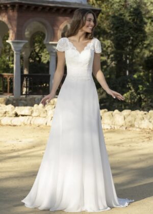 Robe de mariée élégante et romantique, dotée d'un corsage en dentelle florale finement travaillée, avec des manches courtes festonnées et une jupe fluide en mousseline légère, idéale pour un mariage en extérieur ou un cadre champêtre
