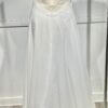 Vue de face d'une mariée en robe blanche à manches courtes et encolure en V ornée de dentelle délicate