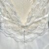 Vue de face d'une mariée en robe blanche à manches courtes et encolure en V ornée de dentelle délicate