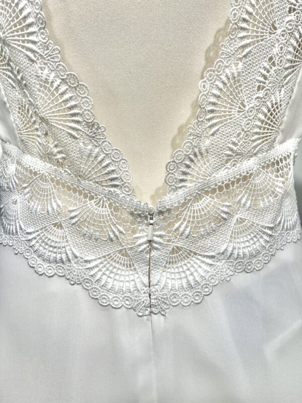 Vue de face d'une mariée en robe blanche à manches courtes et encolure en V ornée de dentelle délicate