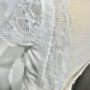 Vue de face d'une mariée en robe blanche à manches courtes et encolure en V ornée de dentelle délicate