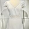 Vue de face d'une mariée en robe blanche à manches courtes et encolure en V ornée de dentelle délicate