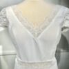 Vue de face d'une mariée en robe blanche à manches courtes et encolure en V ornée de dentelle délicate