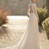 ue arrière d'une mariée dans une robe de mariée à manches longues en dentelle, avec un dos ouvert en dentelle et une traîne fluide