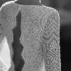 Gros plan sur le motif en dentelle florale des manches longues d'une robe de mariée élégante