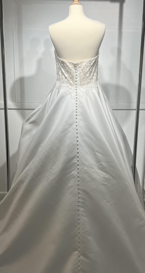 Mariée en robe de mariée classique avec manches bouffantes en tulle, posant dans un jardin luxuriant