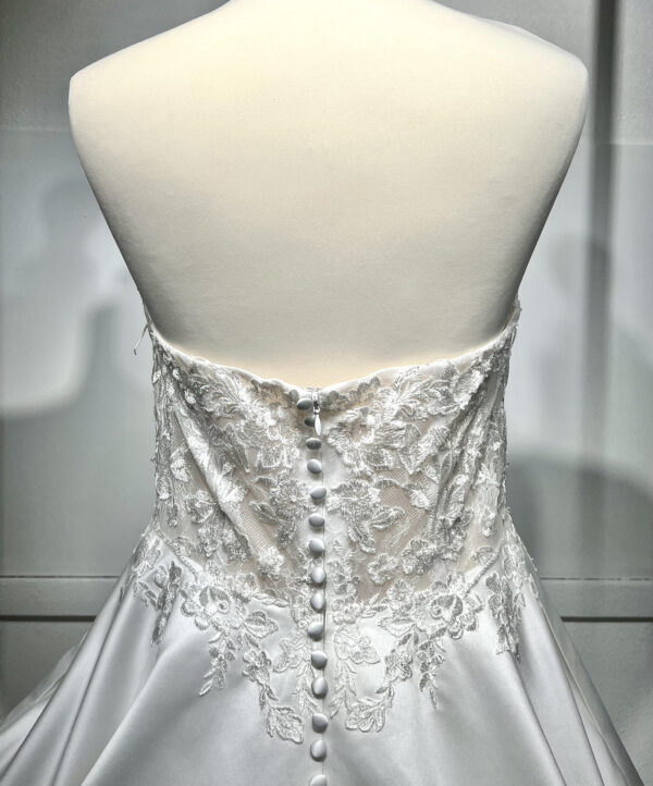 Mariée en robe de mariée classique avec manches bouffantes en tulle, posant dans un jardin luxuriant