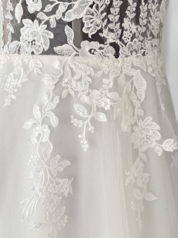 Tulle fluide et appliques de dentelle sur la jupe de la robe Pellagia