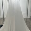 Cette robe de mariée allie minimalisme et élégance avec son corsage ajusté à col carré et sa jupe fluide prolongée d’une traîne légère. Son design épuré s’harmonise parfaitement avec un cadre méditerranéen raffiné, idéal pour une mariée au style intemporel.