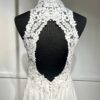 Cette robe de mariée allie raffinement et modernité avec son corsage en dentelle florale et son col haut élégant. Sa jupe fluide crée une silhouette aérienne, sublimée par un décor contemporain. Parfaite pour une mariée en quête de romantisme et de minimalisme.