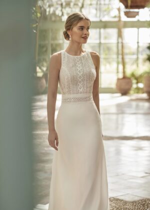 Robe de mariée bohème avec haut en dentelle et manches trois quarts dans un jardin botanique