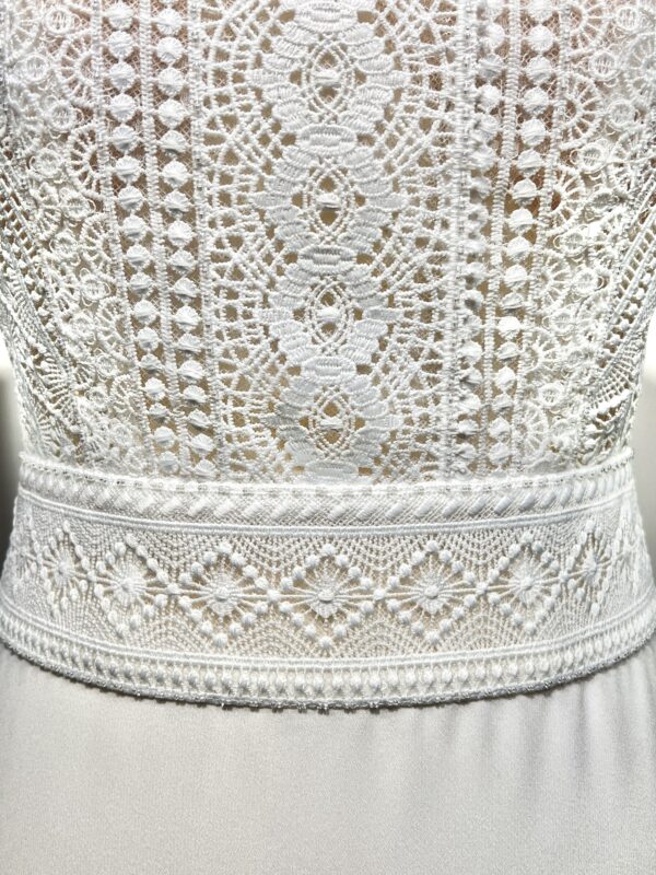 Robe de mariée bohème avec haut en dentelle et manches trois quarts dans un jardin botanique