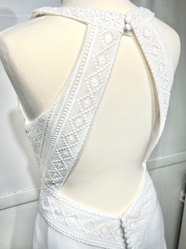 Robe de mariée bohème avec haut en dentelle et manches trois quarts dans un jardin botanique