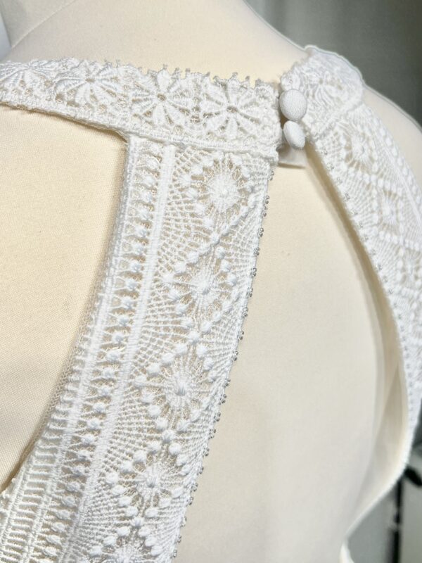 Robe de mariée bohème avec haut en dentelle et manches trois quarts dans un jardin botanique