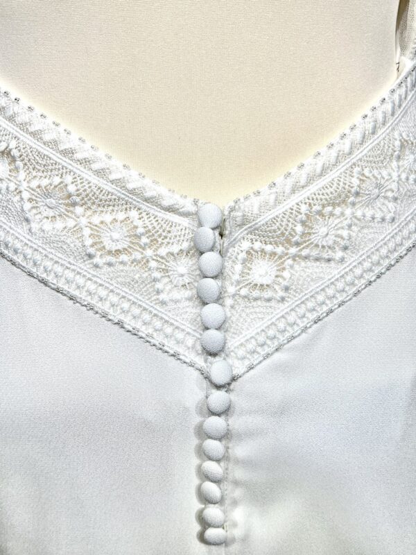 Robe de mariée bohème avec haut en dentelle et manches trois quarts dans un jardin botanique