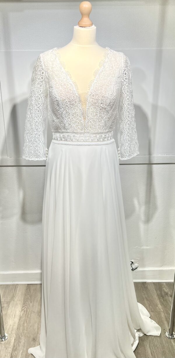 Robe de mariée bohème à manches longues en dentelle dans un jardin intérieur verdoyant