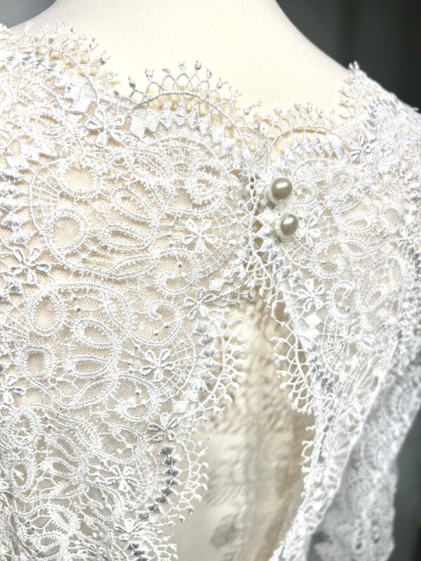 Robe de mariée bohème à manches longues en dentelle dans un jardin intérieur verdoyant