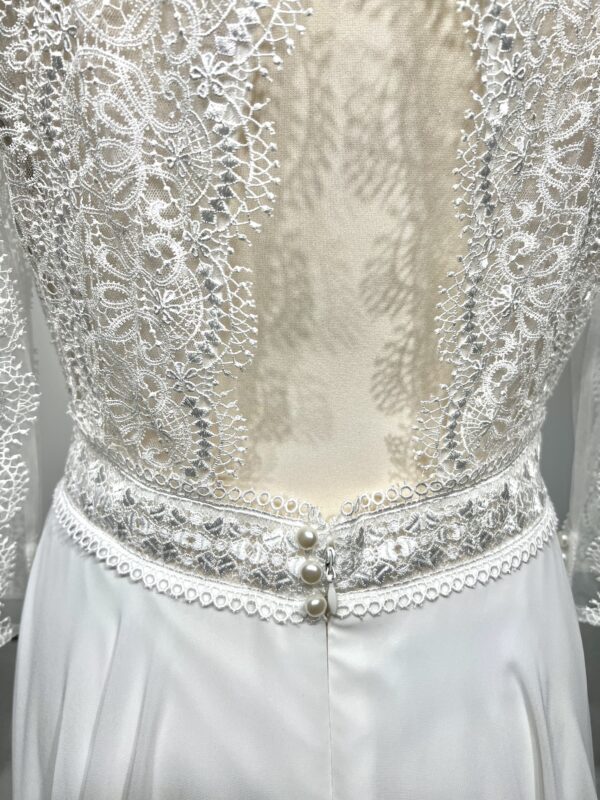 Robe de mariée bohème à manches longues en dentelle dans un jardin intérieur verdoyant