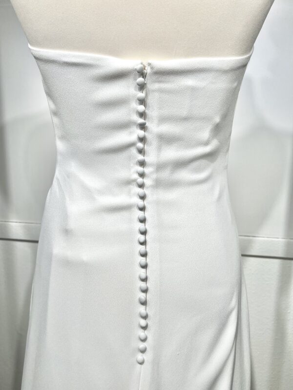 Mariée en robe de mariée en dentelle avec manches trois-quarts, posant dans un cadre floral intérieur