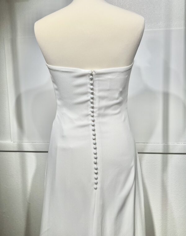 Mariée en robe de mariée en dentelle avec manches trois-quarts, posant dans un cadre floral intérieur