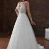 Une femme porte une robe de mariée élégante avec un corsage en dentelle perlée et un décolleté plongeant, soulignant une silhouette délicatement ajustée et une jupe évasée en tulle scintillant