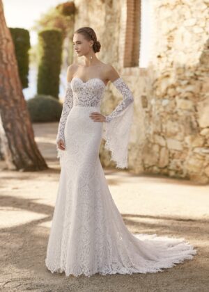 Robe de mariée en dentelle à manches trois-quarts avec détails floraux, avec une mariée élégante en pleine conversation avec un homme en costume beige