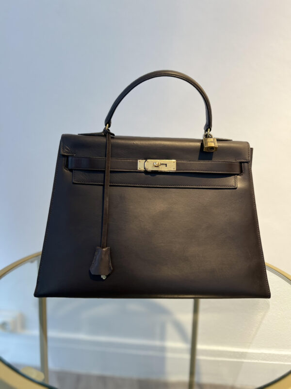 Sac Kelly Hermès vintage en veau box, avec bijouterie en métal plaqué or. Modèle iconique et rare, disponible en plusieurs dimensions et coloris.