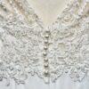 Robe de mariée Megan d'Alma Novia, en dentelle avec dos nu, et coupe fluide.