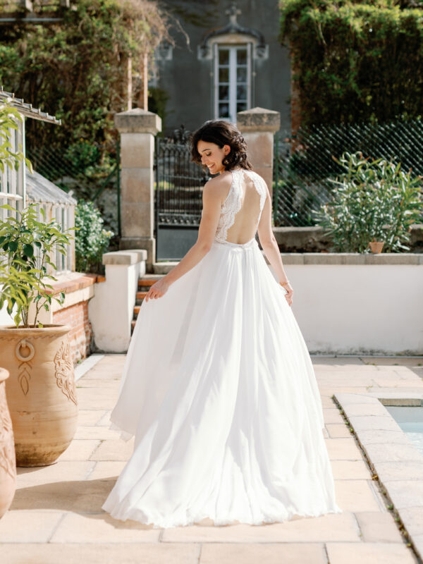 Robe de mariée Angeola Tenerife en dentelle florale avec un corsage structuré, dos nu, jupe fluide en mousseline et traîne élégante.