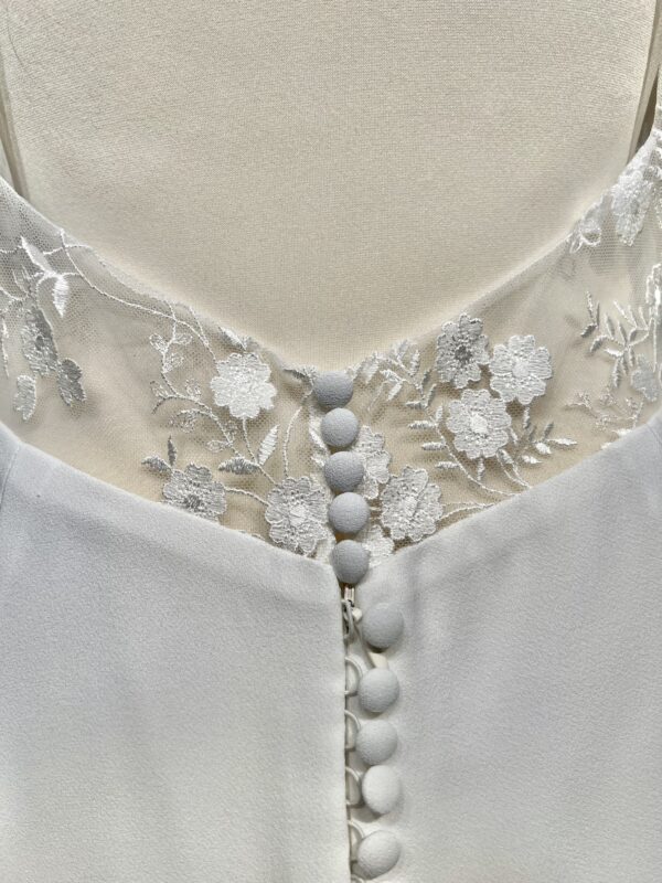 Robe de mariée Angeola Tenerife en dentelle florale avec un corsage structuré, dos nu, jupe fluide en mousseline et traîne élégante.