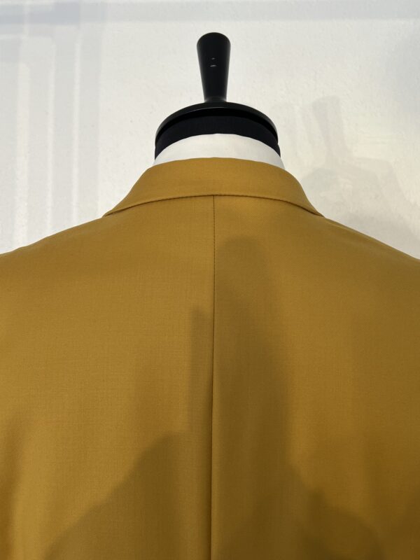 Costume trois pièces jaune moutarde Enzo Romano avec veste structurée, gilet orné de quatre boutons et pantalon à coupe ajustée, accompagné d'une cravate assortie à motifs.