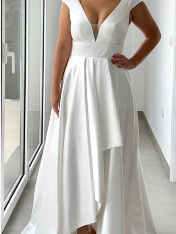 Robe de mariée en satin blanc avec décolleté en V, coupe fluide et jupe asymétrique ornée de drapés délicats.