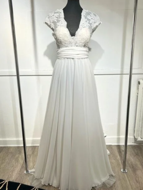 Robe de mariée Blandine de Cymbeline en dentelle florale avec dos nu et jupe fluide en mousseline, portée en extérieur.