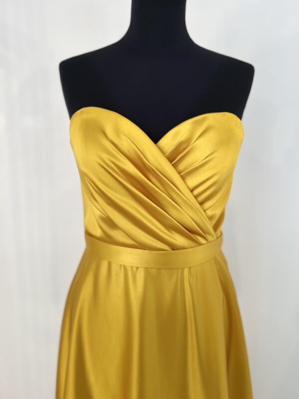 Robe de cocktail longue en satin jaune, sans manches, ajustée au buste avec une coupe fluide et un tombé élégant jusqu’au sol.