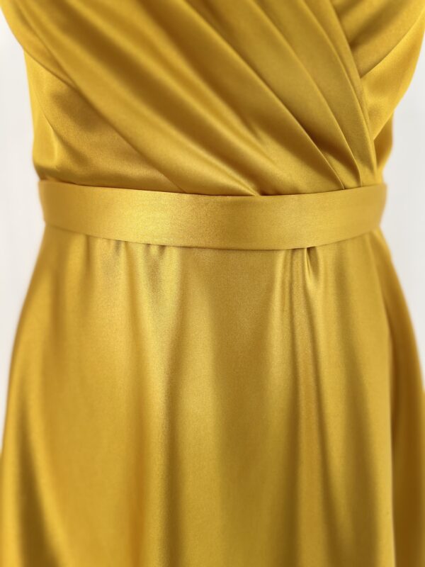 Robe de cocktail longue en satin jaune, sans manches, ajustée au buste avec une coupe fluide et un tombé élégant jusqu’au sol.