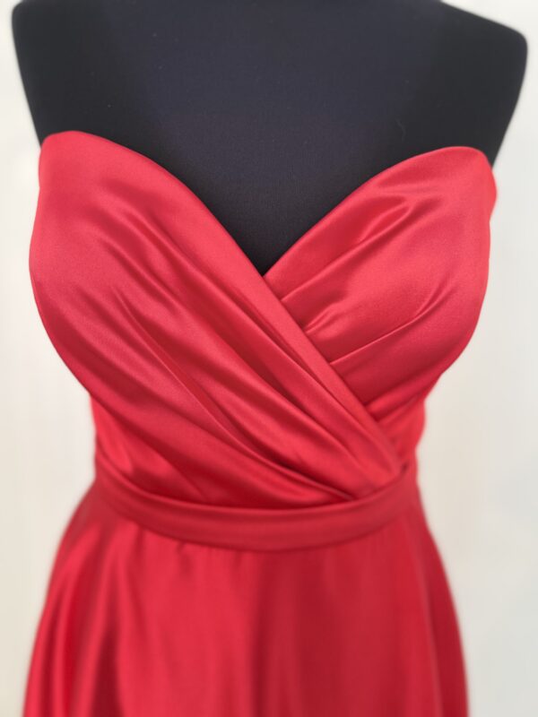 Robe de cocktail courte en satin rouge, avec un bustier cœur drapé et une ceinture fine, offrant une coupe fluide et moderne.