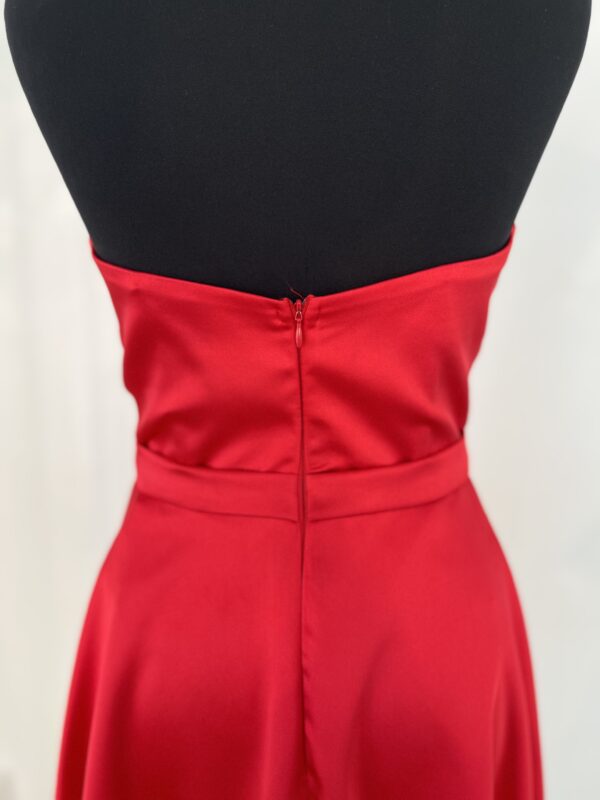 Robe de cocktail courte en satin rouge, avec un bustier cœur drapé et une ceinture fine, offrant une coupe fluide et moderne.