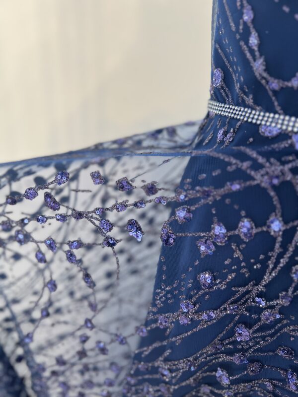 Robe de soirée longue bleu marine ornée de sequins scintillants, avec décolleté en V et silhouette fluide.