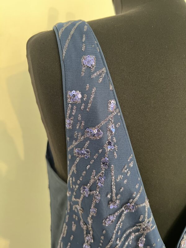 Robe de soirée longue bleu marine ornée de sequins scintillants, avec décolleté en V et silhouette fluide.